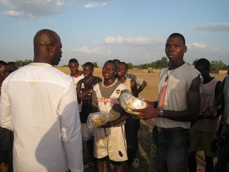 Malamine Kon ( gauche) remet des ballons  des jeunes lors d'un arrt improvis