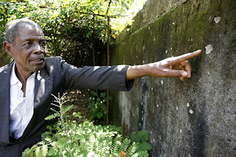 Jean Marie Dor montre un mur de sa maison atteint par des impacts de balle lors de la rpression du 28 septembre 2009