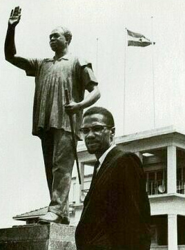 Malcolm X au Ghana. A l'arrire plan, une statue de Kwame Nkrumah