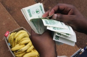 Un Zimbabwen compte ses billets afin d'acheter des bananes.