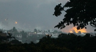 Du feu et de la fume s'chappent du camp militaire d'Akouedo bombard par des hlicoptres de l'Onuci