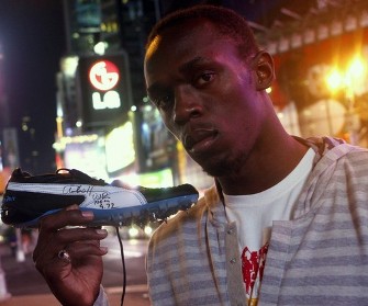 Usain Bolt pose avec la paire de chaussures qui lui a permis de battre le record du monde du 100 mètres